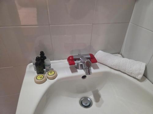 a white bathroom sink with a faucet and towels at Zeus room 3 beds in Panagia