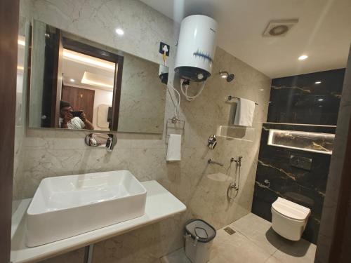 a bathroom with a sink and a toilet and a mirror at Hotel The R L Palace - "A Luxurious Hotel" 900 Meters From Ram Mandir Ayodhya in Ayodhya