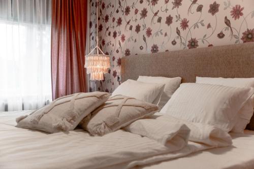 a bed with white sheets and pillows in a bedroom at Künni Villa, saun ja mullivann in Viljandi