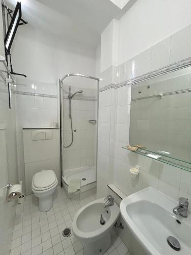 ein weißes Badezimmer mit Toilette und Waschbecken in der Unterkunft Hotel Caracas in Cattolica