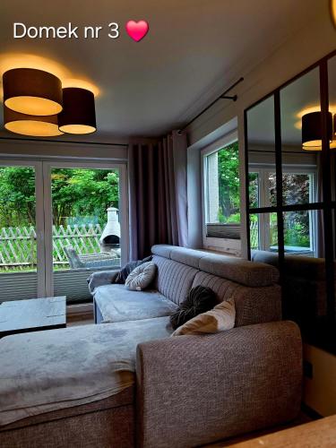 a living room with two couches and two windows at Zacisze Pod Śmielcem in Jagniątków