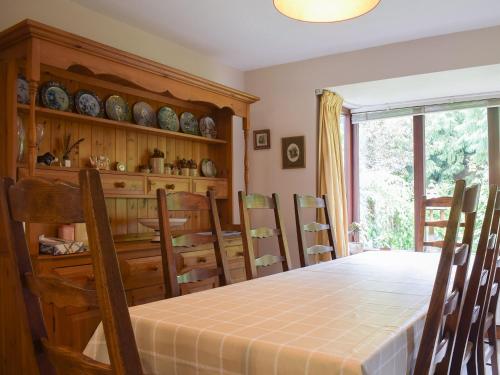 a dining room with a table and chairs and a window at Kuliguni in Ross on Wye