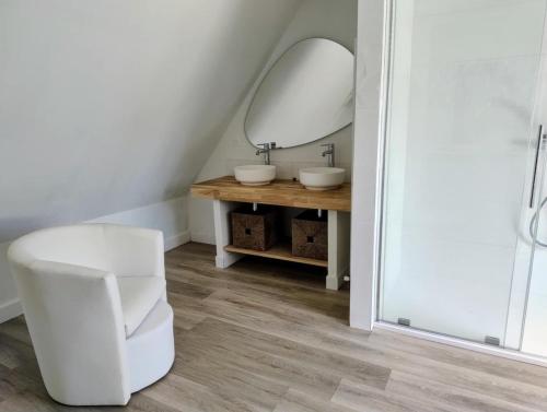 une salle de bain avec des toilettes blanches et un miroir dans l'établissement Ty Carbon proche des plages, à Fouesnant