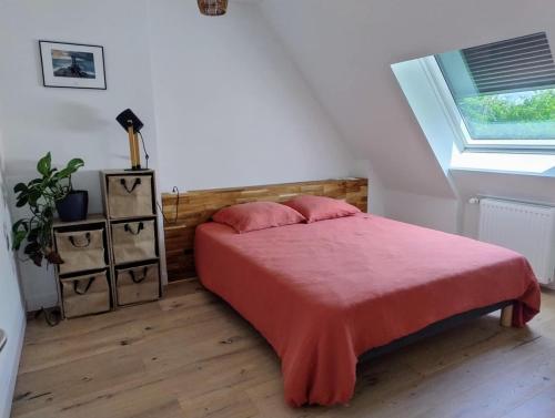 une chambre avec un lit avec une couverture rouge et une fenêtre dans l'établissement Ty Carbon proche des plages, à Fouesnant
