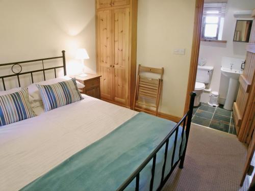 a bedroom with a bed and a bathroom with a sink at The Granary in Great Ormside