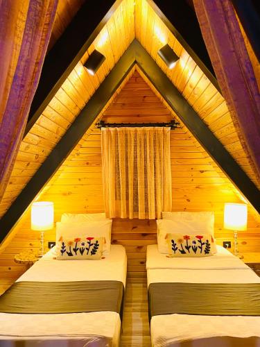 a bedroom with two beds in a wooden house at Garden Bungalows and Suites in Antalya