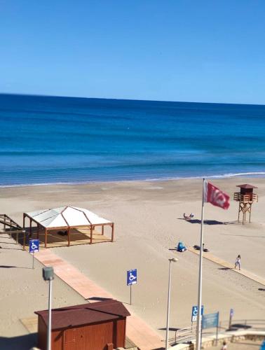 a beach with a pavilion and the ocean at Apartamento en Primera Línea in Cullera