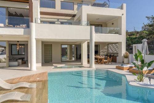 a villa with a swimming pool in front of a house at Luxurious Villa Selestine - With Private Pool in Panormos Rethymno