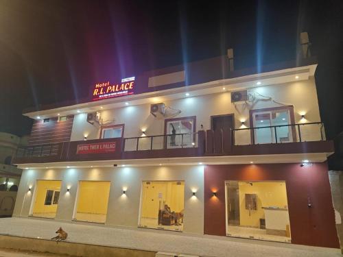 a building with a sign on top of it at night at Hotel The R L Palace - "A Luxurious Hotel" 900 Meters From Ram Mandir Ayodhya in Ayodhya