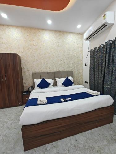 a bedroom with a large bed with blue pillows at Hotel The R L Palace - "A Luxurious Hotel" 900 Meters From Ram Mandir Ayodhya in Ayodhya
