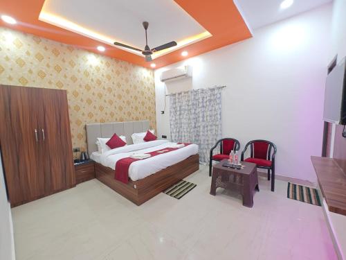 a bedroom with a bed and a table and chairs at Hotel The R L Palace - "A Luxurious Hotel" 900 Meters From Ram Mandir Ayodhya in Ayodhya