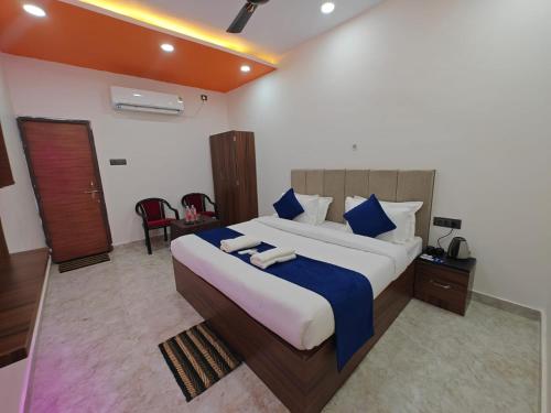 a bedroom with a large bed with blue and white pillows at Hotel The R L Palace - "A Luxurious Hotel" 900 Meters From Ram Mandir Ayodhya in Ayodhya