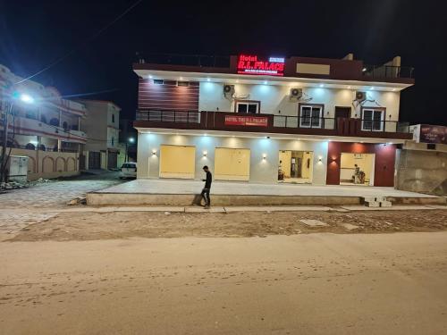 a person walking in front of a building at night at Hotel The R L Palace - "A Luxurious Hotel" 900 Meters From Ram Mandir Ayodhya in Ayodhya