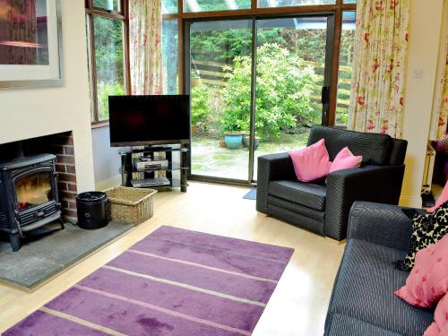 a living room with a fireplace and a tv at Bank End in Glenridding