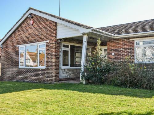 a brick house with a window and a yard at Botany Bay Bungalow in Kingsgate