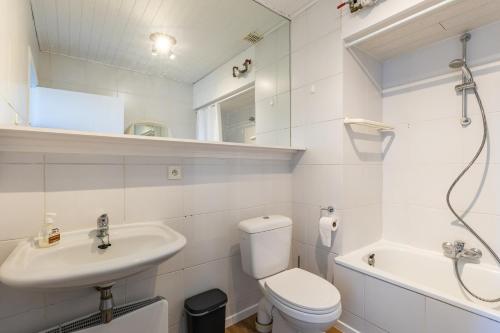 a bathroom with a sink and a toilet and a bath tub at Ermitage 0204 P in Oostduinkerke