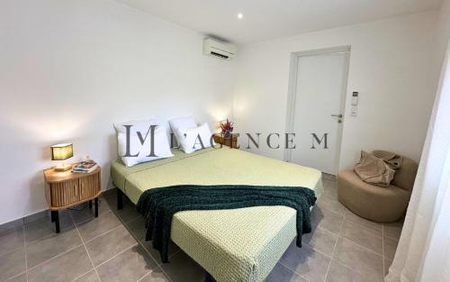 une chambre d'hôtel avec un lit et une chaise dans l'établissement Appartement Petru Paisible & spacieux, à Calvi