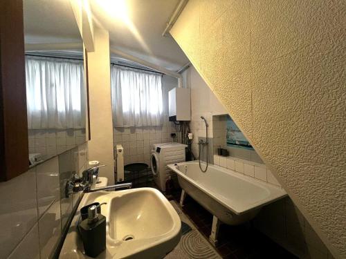 ein weißes Badezimmer mit Waschbecken und Spiegel in der Unterkunft Apartmán V Srdci Varů in Karlsbad