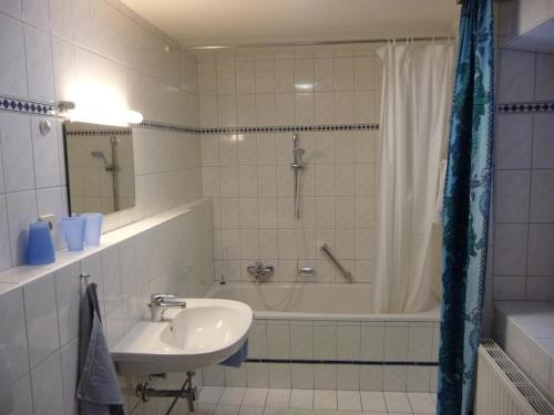 ein Badezimmer mit einem Waschbecken, einer Dusche und einer Badewanne in der Unterkunft Landhaus Fiausch in Mallnitz