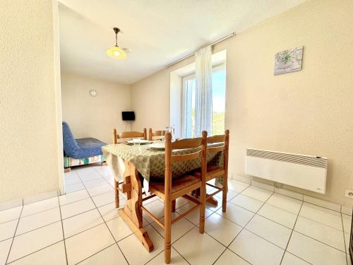 une salle à manger avec une table et des chaises et une fenêtre dans l'établissement La Vallée Appartement 35 - Thermes Neyras les Bains, à Meyras