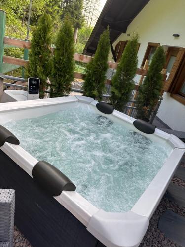 a hot tub on a patio with plants at Ski Lodge Pampeago in Tesero