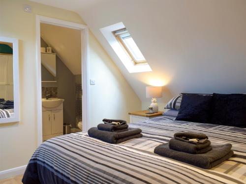 a bedroom with a bed with towels on it at Windhover in Glasbury