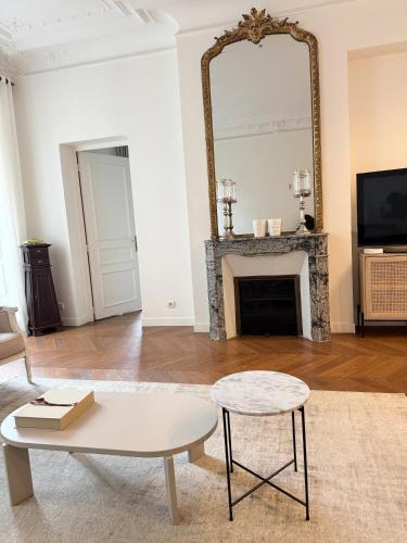 un salon avec une cheminée et un miroir dans l'établissement Central Champs Élysée - High Luxury 2 Bedroom Apartment, à Paris