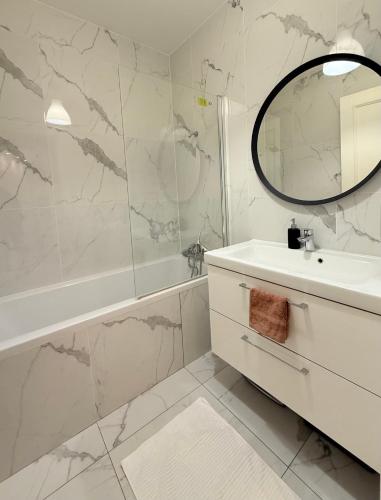 une salle de bain blanche avec un lavabo et un miroir dans l'établissement Central Champs Élysée - High Luxury 2 Bedroom Apartment, à Paris