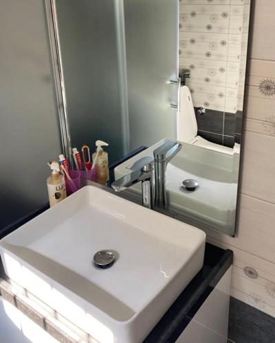 a bathroom with a white sink and a mirror at Vila Malti in Piqeras