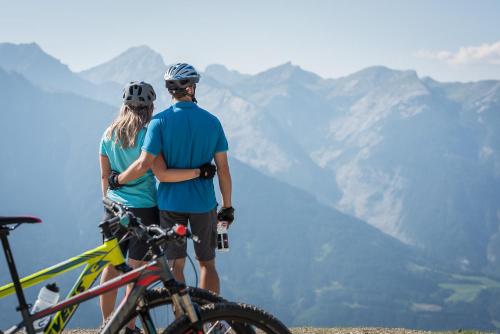 a couple standing on top of a mountain with their bikes at Ferienhaus Hubertus Tirol 1-8 Personen in Pill