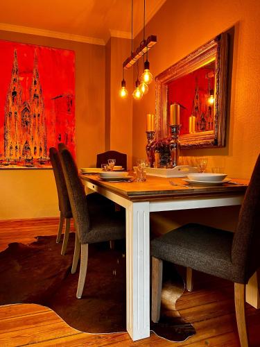 a dining room table with chairs and a large mirror at Stylischer Altbau im Zentrum in Kiel