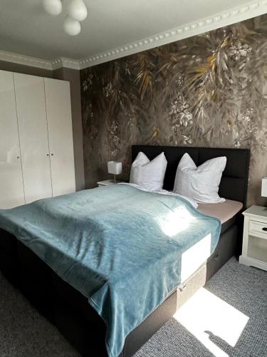 a bedroom with a large bed with a blue blanket at Stylischer Altbau im Zentrum in Kiel