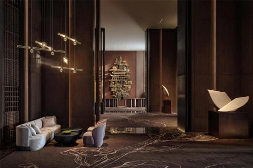 a lobby with a couch and chairs in a building at Conrad Shenzhen, the first art museum hotel in Greater Bay Area with the stunning bay and sunset view in the hotel terrace in Shenzhen