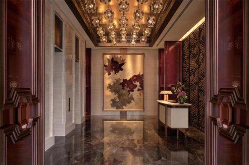 a hallway with a painting and a chandelier at Conrad Shenzhen, the first art museum hotel in Greater Bay Area with the stunning bay and sunset view in the hotel terrace in Shenzhen