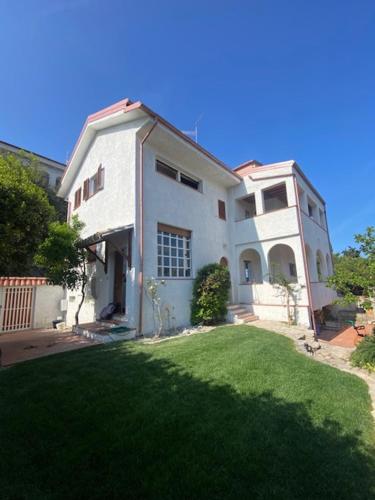 a large white house with a lawn in front of it at Villa Saracena in Francavilla al Mare