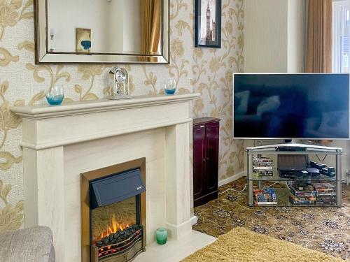 Il comprend un salon doté d'une cheminée et d'une télévision à écran plat. dans l'établissement The Bay Cottage, à Thornton
