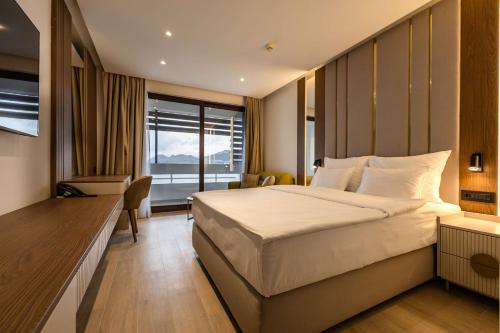 a hotel room with a large bed and a desk at Radisson Resort Ruza Vjetrova in Dobra Voda