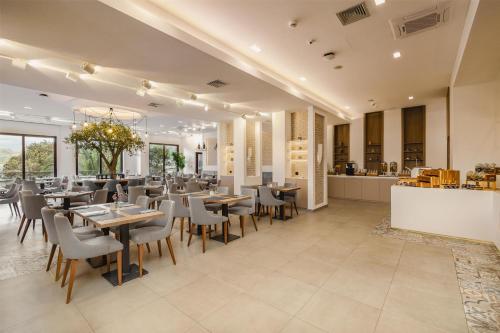 a restaurant with tables and chairs and a counter at Radisson Resort Ruza Vjetrova in Dobra Voda