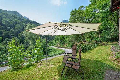 a pair of chairs and an umbrella on the side of a road at Le Fratte in Pertica Alta