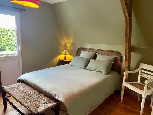 une chambre avec un lit, une chaise et une fenêtre dans l'établissement La Kalinka Maison réconfortante au calme et proche du centre, à Saint-Brieuc