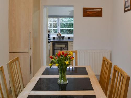 a dining room table with a vase of flowers on it at Oakwood in Bridlington