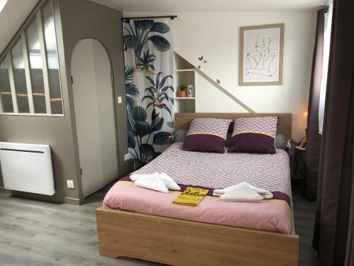 une chambre avec un lit avec deux serviettes dessus dans l'établissement Nid douillet Lorientais, à Lorient