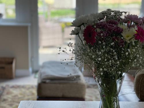 a vase filled with flowers sitting on a table at Two Hoots in Wigglesworth