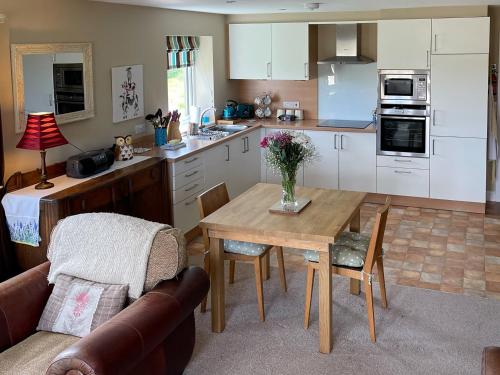 a kitchen with a wooden table and a dining room at Two Hoots in Wigglesworth