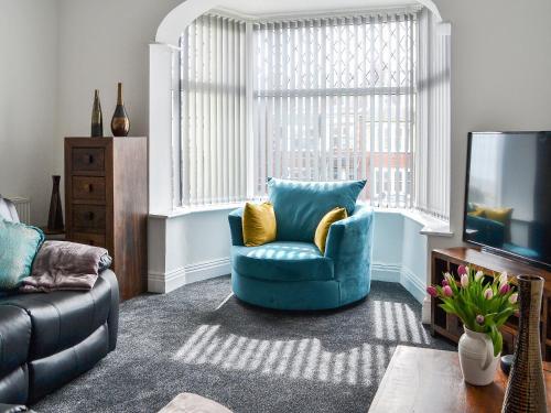 sala de estar con silla azul y TV en Seaforth House, en Bridlington