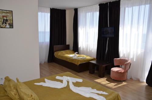 a hotel room with two beds and clothes on the floor at Vila Julia Costinesti in Costinesti