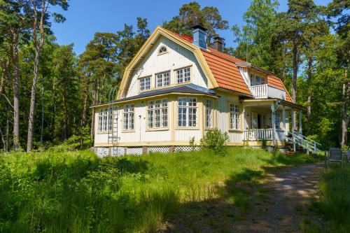 a house with an orange roof in a field at Honkala in Turku