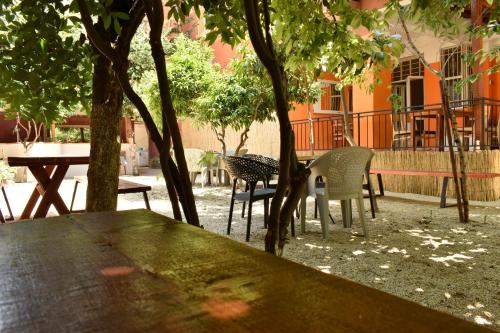 a table and chairs under a tree in a yard at Trip'n'Hostel Pink Bubble in Tirana