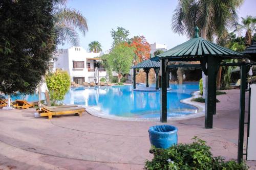 a large pool with a gazebo and a swimming pool at Downtown,Delta sharm in Sharm El Sheikh