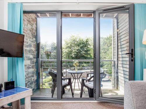 een woonkamer met glazen schuifdeuren naar een patio bij 4 Water Wheel Apartment in Charlestown